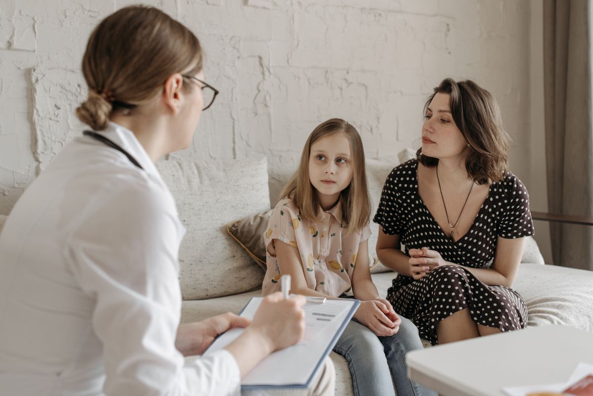 A clinician talking with a mother and her daughter