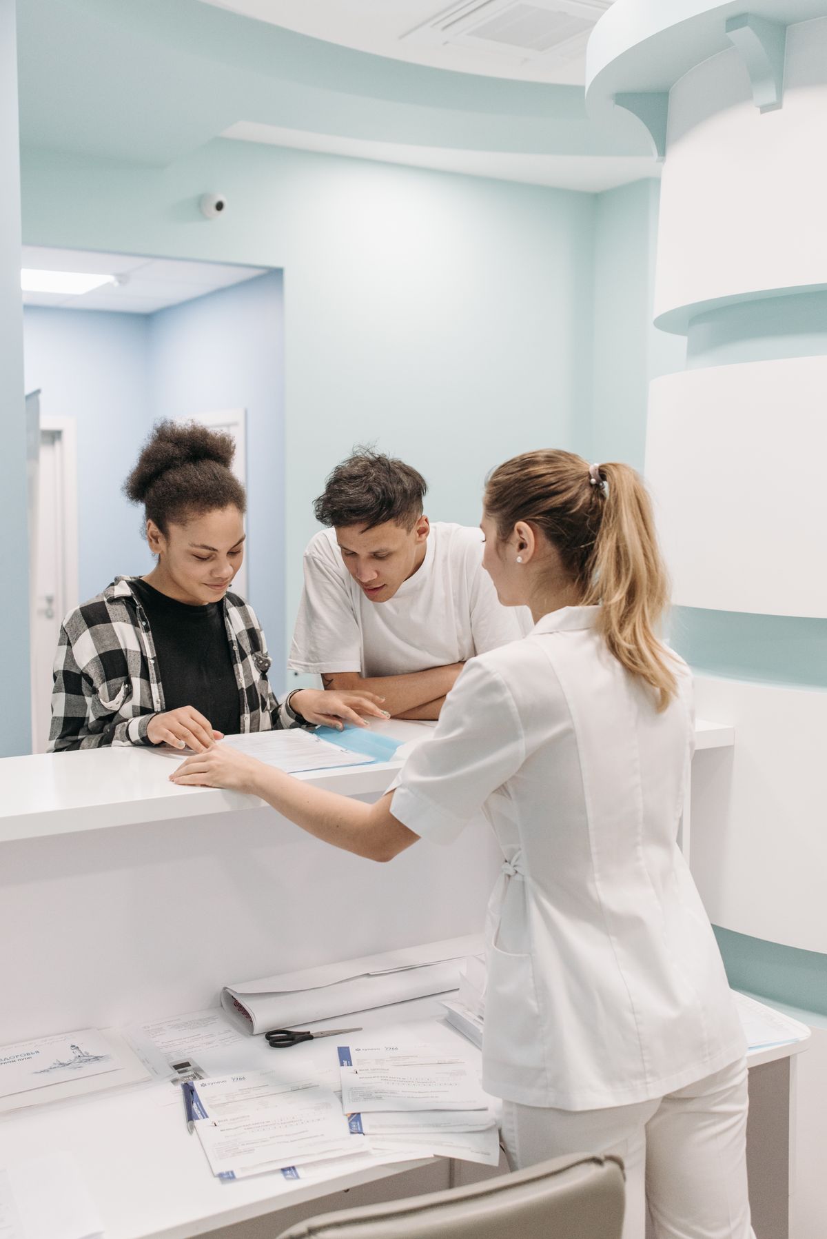 Front-desk staff assisting patients at a medical office